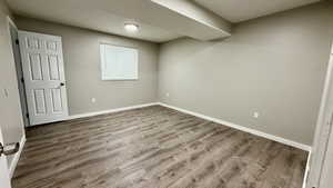 Unfurnished bedroom with wood finished floors and baseboards