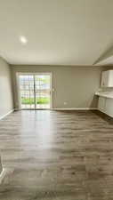 Unfurnished living room with baseboards and wood finished floors