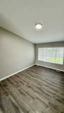 Spare room with baseboards and wood finished floors