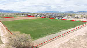 Aerial perspective of suburban area with property boundaries highlighted and a mountainous background
