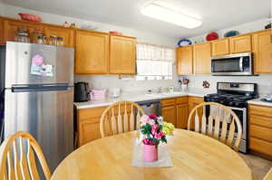 Kitchen featuring light countertops, appliances with stainless steel finishes, and a sink