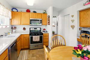 Kitchen featuring a sink, stainless steel appliances, and light countertops