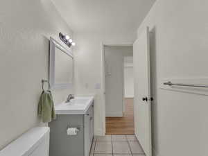 Bathroom featuring tile patterned flooring, vanity, toilet, and baseboards