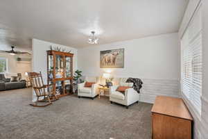 Living room with carpet flooring and a ceiling fan