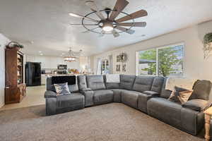 Living room with a chandelier, ceiling fan, a textured ceiling, and recessed lighting