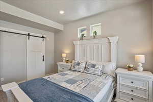 Bedroom with a barn door and baseboards