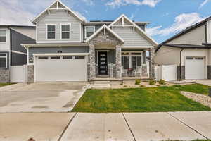 Craftsman house with covered porch, stone siding, concrete driveway, and a garage