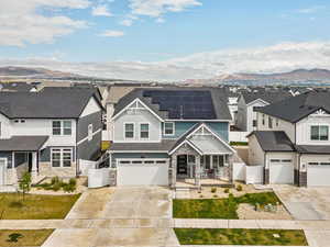 View of front of property featuring stone siding, a residential view, covered porch, driveway, and a mountain view