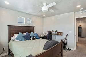 Bedroom with carpet floors, ceiling fan, baseboards, and a textured ceiling