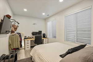 Bedroom featuring wood finished floors, recessed lighting, and an office area