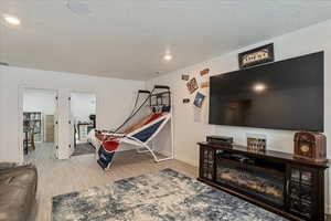 Playroom with wood finished floors, recessed lighting, a textured ceiling, and baseboards