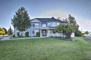 Victorian-style house with a front lawn and a porch