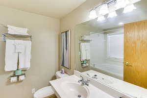 Full bathroom with toilet, shower / bath combination, an inviting chandelier, and a sink
