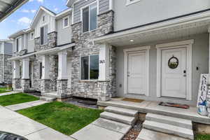 Doorway to property with stone siding and stucco siding