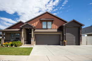 Craftsman house with driveway, board and batten siding, a garage, and stucco siding