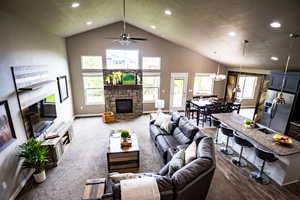 Living area with a fireplace, recessed lighting, carpet, baseboards, and ceiling fan