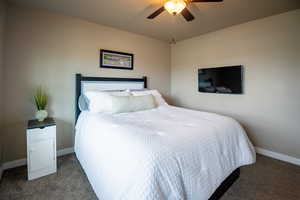 Carpeted bedroom featuring baseboards and a ceiling fan