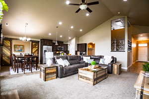 Living room with a barn door, ceiling fan, light colored carpet, recessed lighting, and baseboards