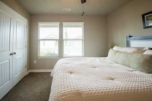 Bedroom featuring carpet floors, a closet, baseboards, and a ceiling fan