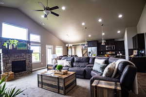 Living area featuring high vaulted ceiling, carpet flooring, a fireplace, a ceiling fan, and recessed lighting