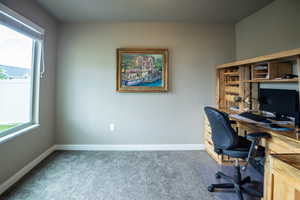 Carpeted office space featuring baseboards