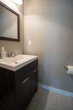 Bathroom featuring vanity, tile patterned flooring, and baseboards