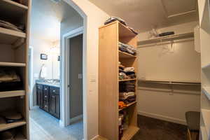 Spacious closet featuring arched walkways and light tile patterned flooring
