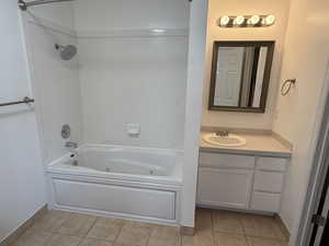 Bathroom featuring tile patterned flooring, a combined bath / shower with jetted tub, and vanity