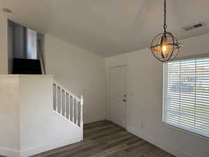 Entrance foyer featuring stairway, dark wood finished floors, baseboards, and a chandelier
