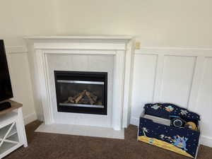 Detailed view of carpet floors, a tile fireplace, and a decorative wall