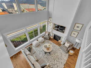 Living room featuring a towering ceiling, visible vents, a wealth of natural light, and wood finished floors