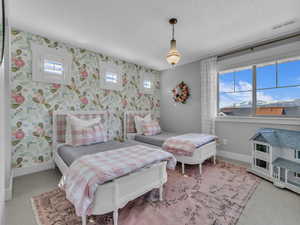 Carpeted bedroom with wallpapered walls and carpeting