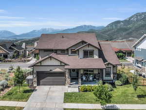 View of front facade with fence, board and batten siding, a shingled roof, and concrete driveway