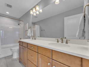 Bathroom featuring toilet, double vanity, a sink
