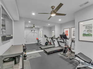 Exercise room with a ceiling fan, recessed lighting, and mirrored wall