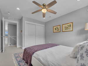 Bedroom featuring a closet, baseboards, and light carpet