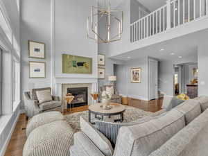 Vaulted ceilings in living room featuring  a gas fireplace, lots of natural light and wood finished floors
