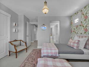 Bedroom with wallpapered walls, carpet floors, and baseboards