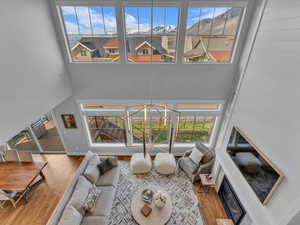 Living room featuring a towering ceiling, wood finished floors and generous natural light