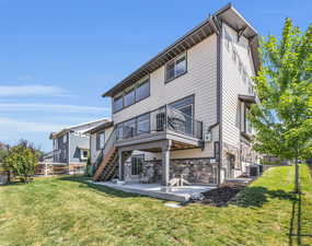 Back of house with deck from main level, covered patio on ground level, landscaping and fully fenced