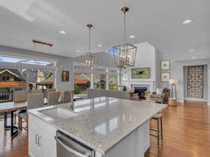 Kitchen with stainless steel dishwasher, generous island with bar seating and a healthy amount of sunlight