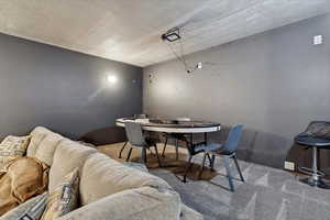 Carpeted dining space featuring a textured ceiling