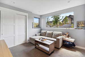 Carpeted living area with baseboards and recessed lighting