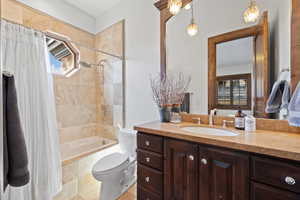 Bathroom with vanity, toilet, tiled shower / bath, and a healthy amount of sunlight