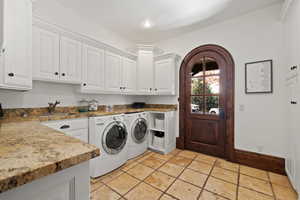 Laundry area with a sink, separate washer and dryer, cabinet space, stone tile flooring, and recessed lighting