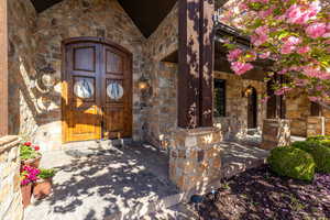 View of exterior entry featuring stone siding and covered porch