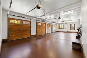 Garage with baseboards and a garage door opener