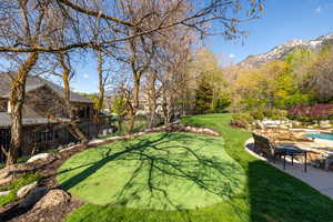 View of yard featuring a patio area, a fenced in pool, a mountain view, and fence