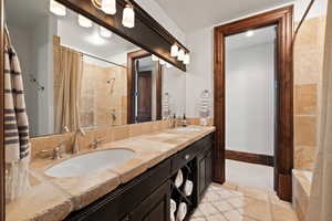 Bathroom featuring double vanity, a sink, and a shower with shower curtain