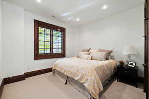 Bedroom featuring light carpet, baseboards, and visible vents